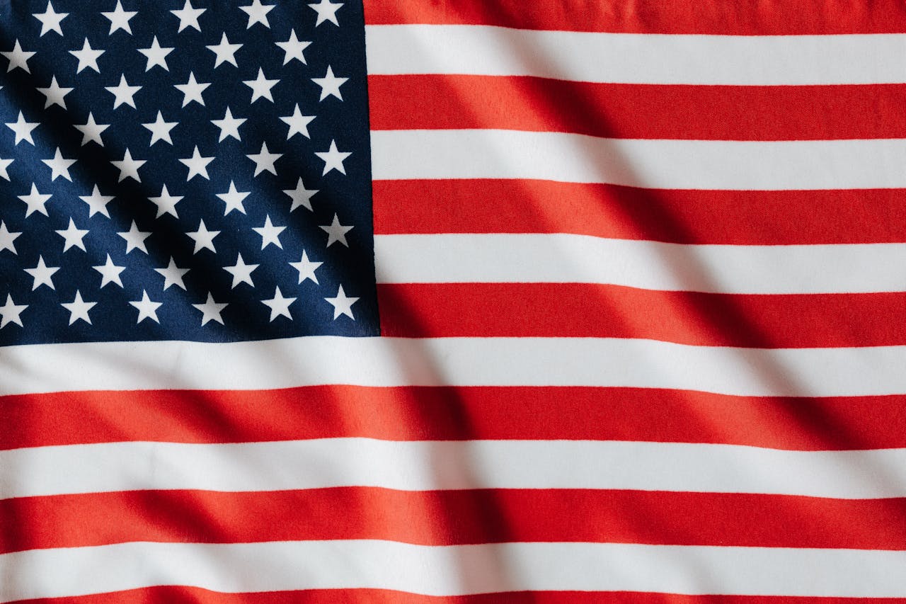 American flag flying on tall flagpole in front of home