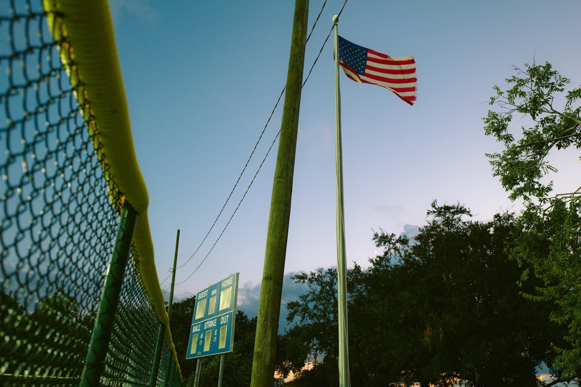 USA flag on tall aluminum flagpole in public square with wide base foundation